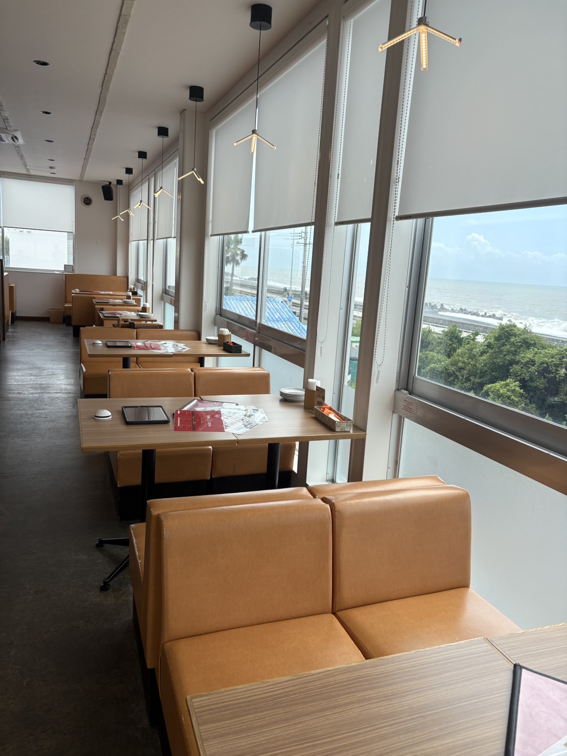 海沿いの窓に面して並ぶテーブル席
